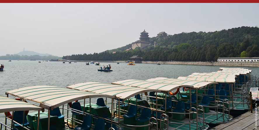 Плавают лодки и катамараны по озеро Куньминху на фоне Холма Долголетия и Храма на горе